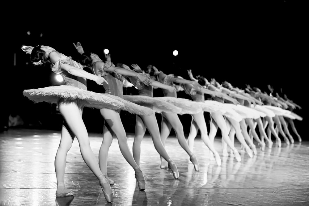 black and white photo of ballet group in a line performing on stage